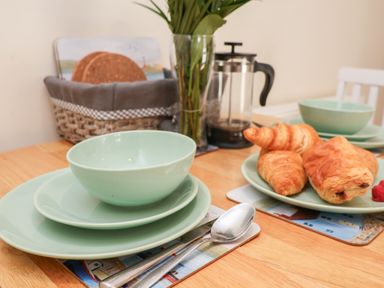 A table set with plates bowls croissants and a coffee press at Church View in Whitby