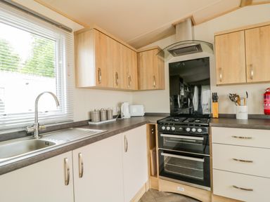 A kitchen with sink oven stove cabinets and utensils at The Hideaway in Cockermouth