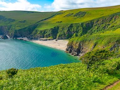 A view of a beach and cliffs at 6 Valley View in Lanreath