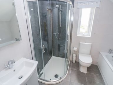 A bathroom with a corner shower enclosure a toilet a sink and a bathtub at Ty'r Winllan in Newport Pembrokeshire