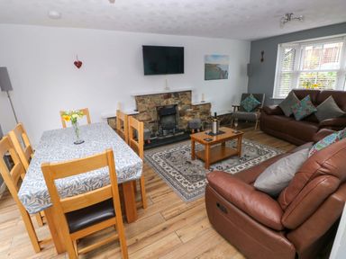 A living room with a dining area and sofa at Ty'r Winllan in Newport, Pembrokeshire