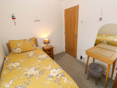 A bedroom with a bed and dressing table at Ty'r Winllan in Newport, Pembrokeshire