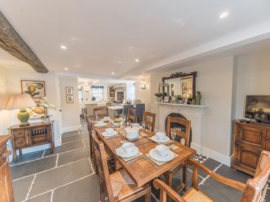 A dining room with a wooden table set for a meal and a fireplace at Prospect House in Ambleside