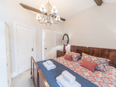 A bedroom with double bed towels on bed wardrobe and chandelier at Prospect House in Ambleside