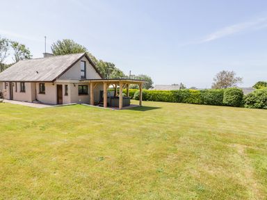A detached house with a covered patio in a large lawn garden at Berwyn in Talybont