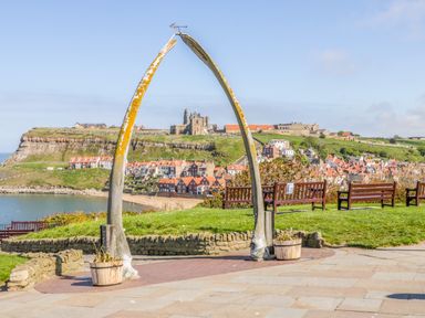 A whale bone arch with benches and a coastal village and abbey in the background at 1 Church Square in Whitby