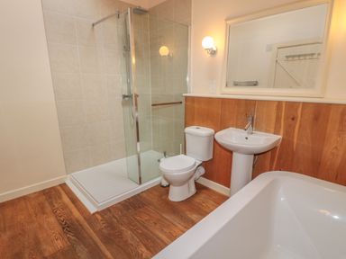 A bathroom with a shower enclosure toilet sink and bathtub at The Long Barn in Berwick-Upon-Tweed