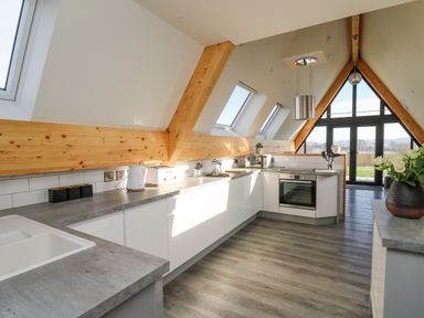 A kitchen with gray countertops white cabinets a stove and skylights at Elan Valley Welsh - The Sheepfold in Llanyre near Llandrindod Wells
