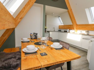 A kitchen with a wooden dining table set with plates bowls and glasses Elan Valley Welsh - The Sheepfold Llanyre near Llandrindod Wells