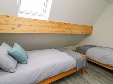 A bedroom with two single beds under a skylight at Elan Valley Welsh - The Sheepfold in Llanyre near Llandrindod Wells
