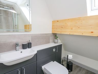 A bathroom with sink and toilet under a slanted ceiling at Elan Valley Welsh - The Sheepfold in Llanyre near Llandrindod Wells