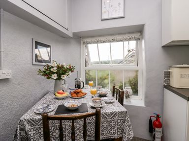 A kitchen nook with a table set for breakfast near a window at Rusland View Rusland near Newby Bridge
