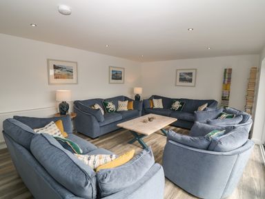 A sitting room with blue sofas and a wooden coffee table at Argraig in Llanbedrog