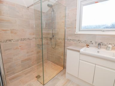 A bathroom with a walk-in shower and a sink with cabinet at Estuary View (House & Annexe) in Dartmouth