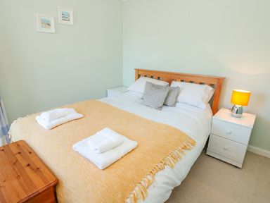 A bedroom with a double bed towels bedside tables and a lamp at Estuary View House Annexe in Dartmouth