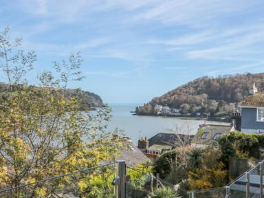 A coastal view with houses trees hills and water at Estuary View House and Annexe in Dartmouth