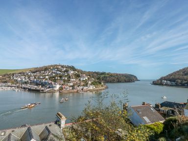 A river with boats and houses on the hillsides at Estuary View House and Annexe in Dartmouth