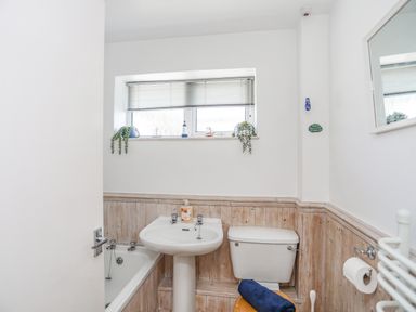 A bathroom with a bathtub sink and toilet at Crows Nest Rhosneigr