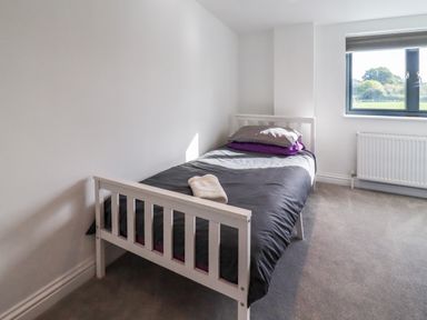 A bedroom with a single bed near a window at Phoenix House in Castlemorton