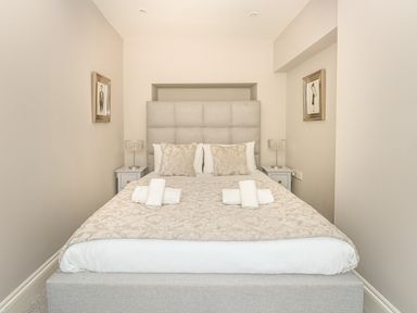 A bedroom with a double bed with two bedside tables and lamps at Harbour Watch 2 in Weymouth