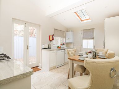 A kitchen with a dining table set for four and a skylight window at Harbour Watch 2 in Weymouth