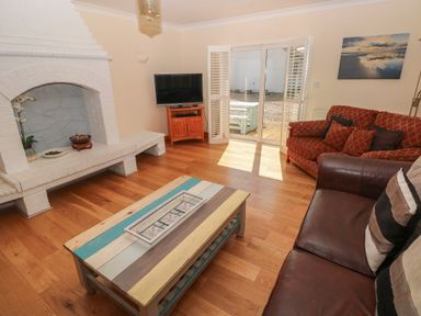 A living room with a fireplace television couches and a coffee table at Yr Hen Ardd in Dale near Milford Haven