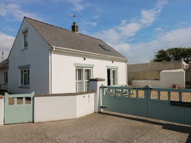 A white house with a grey roof and green gates in a driveway at Yr Hen Ardd in Dale near Milford Haven