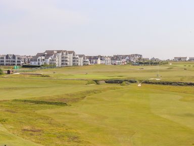 A golf course with residential buildings in the background at 8 Cribbar in Newquay