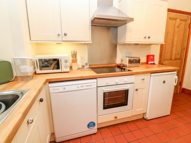 A kitchen with wooden countertops microwave oven toaster and dishwasher at Elmbank in Looe