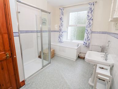 A bathroom with a shower enclosure bathtub toilet and sink at Elmbank in Looe