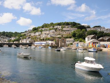 A river with boats and houses on a hillside in the background at Elmbank in Looe