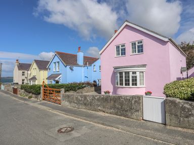 A street with pastel colored houses including a pink house and a blue house at The Pink House in Rhosneigr