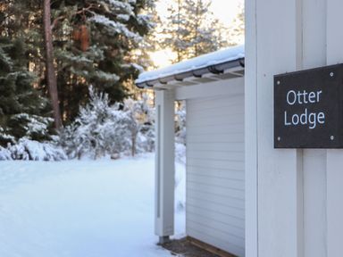 Entry view of Otter Lodge with snow and trees at Otter Lodge in Feshiebridge near Aviemore