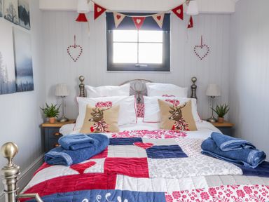 A bedroom with a metal bed frame and patterned quilt at High Rigg Shepherd's Retreat in Brampton Cumbria