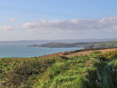 A coastal landscape with grassy fields and cliffs overlooking the sea at Kernyk Rinsey near Porthleven