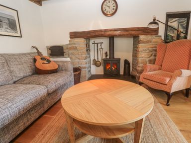 A living room with a fireplace and sofa at Kernyk Rinsey near Porthleven