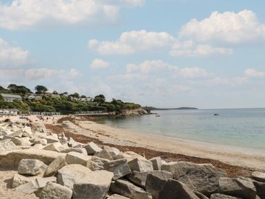 A beach with sand rocks and people near the sea at Deja Blue in Falmouth