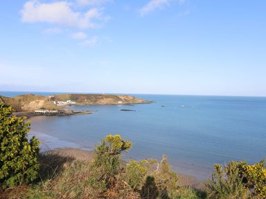 A coastal bay with sandy beach bushes and hills at The Old Boat Store in Morfa Nefyn