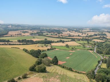 Aerial view of farmland with fields trees and a road at Hunters Moon in Tenbury Wells