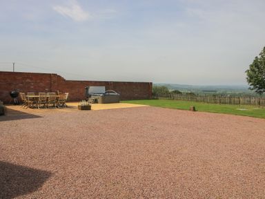 An outdoor area with a table, chairs, and a hot tub at Hunters Moon, Tenbury Wells