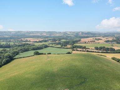 A rural landscape with fields trees and hills under a blue sky at Hilltop House in Tenbury Wells