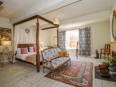 A bedroom with a canopy bed and sitting area at Hilltop House in Tenbury Wells