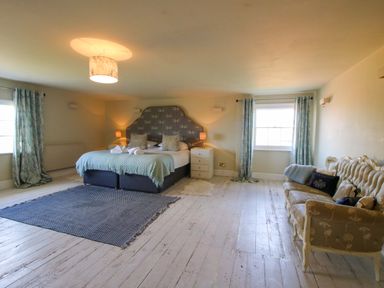 A bedroom with a bed and a sofa at Hilltop House in Tenbury Wells