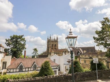 A view of a church with a lamp post and buildings in the foreground at Hilltop House Tenbury Wells