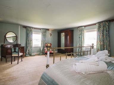 A bedroom with a bed and a dressing table at Hilltop House Tenbury Wells