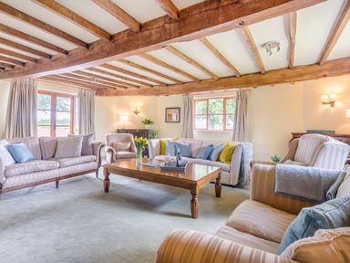 A living room with wooden beams on the ceiling sofas and a wooden coffee table at The Chestnuts in Tenbury Wells