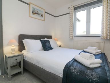 A bedroom with a bed and bedside tables with lamps at Chilton in Bude
