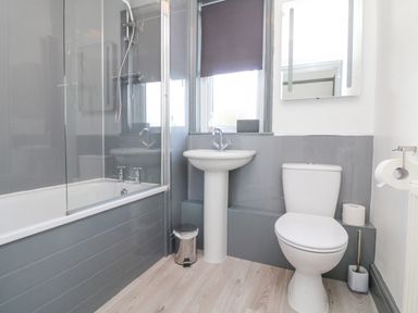 A bathroom with a bathtub shower combination a pedestal sink and a toilet at Chilton in Bude