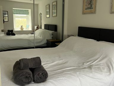 A bedroom with two beds and towels on a bed at Tyddyn Serri in Rhosneigr