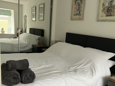 A bedroom with a bed and towels on the side at Tyddyn Serri in Rhosneigr